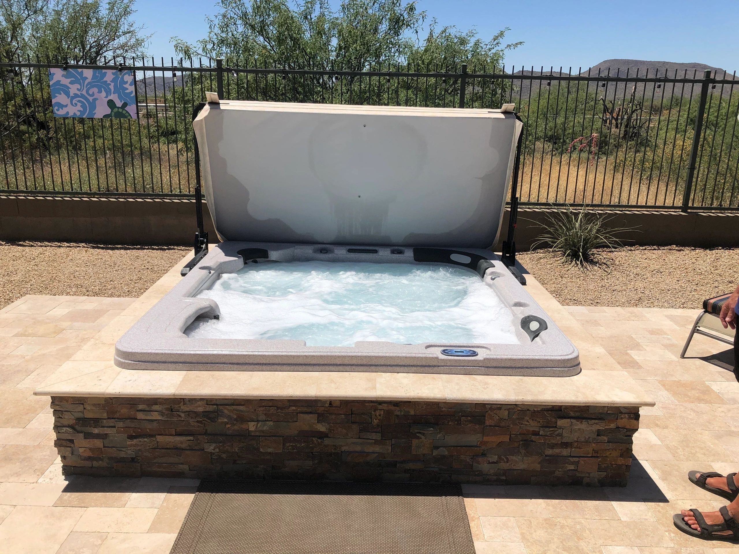 A hot tub sitting on top of a stone bench.