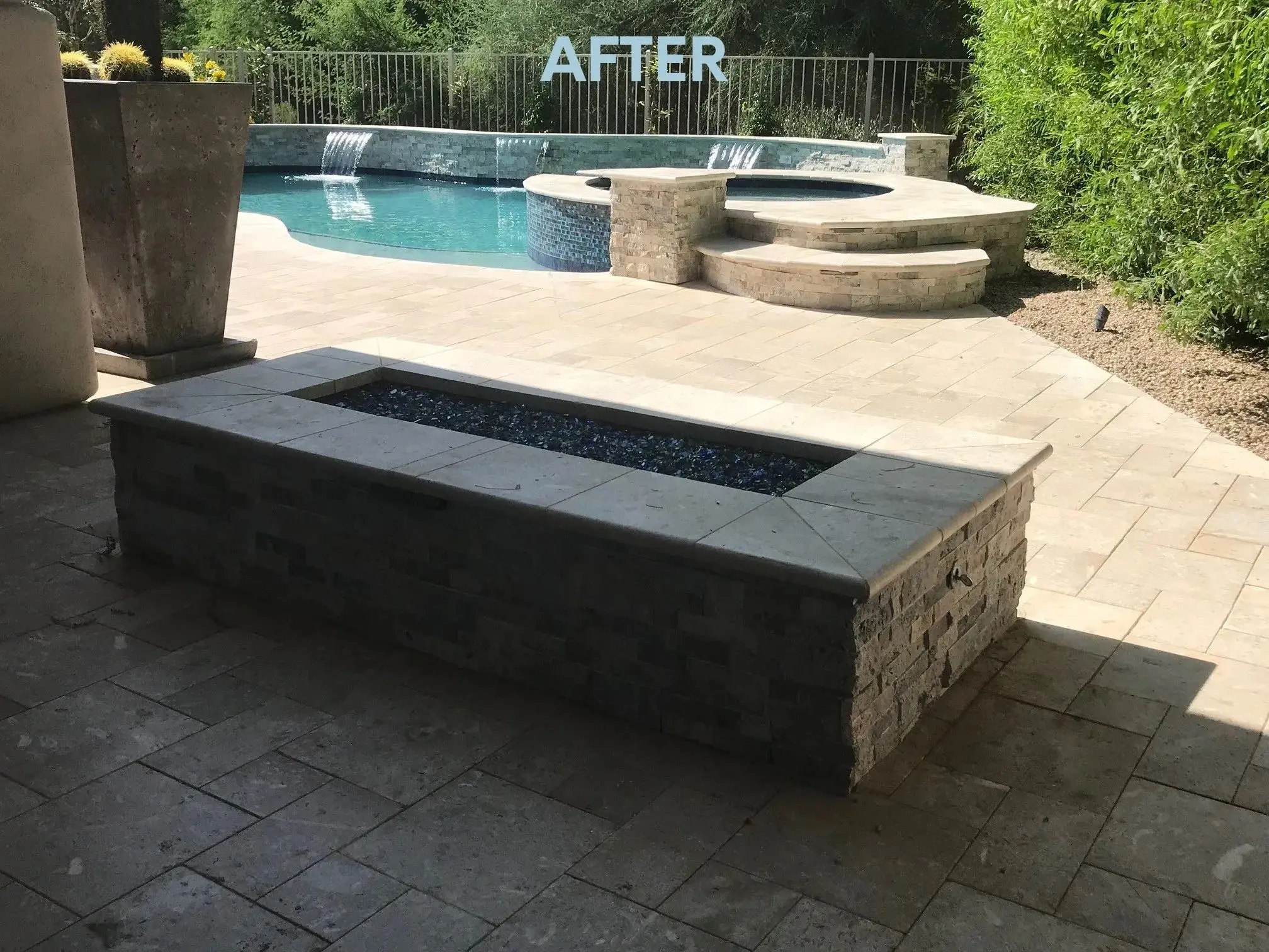 A fire pit sitting next to the side of a pool.