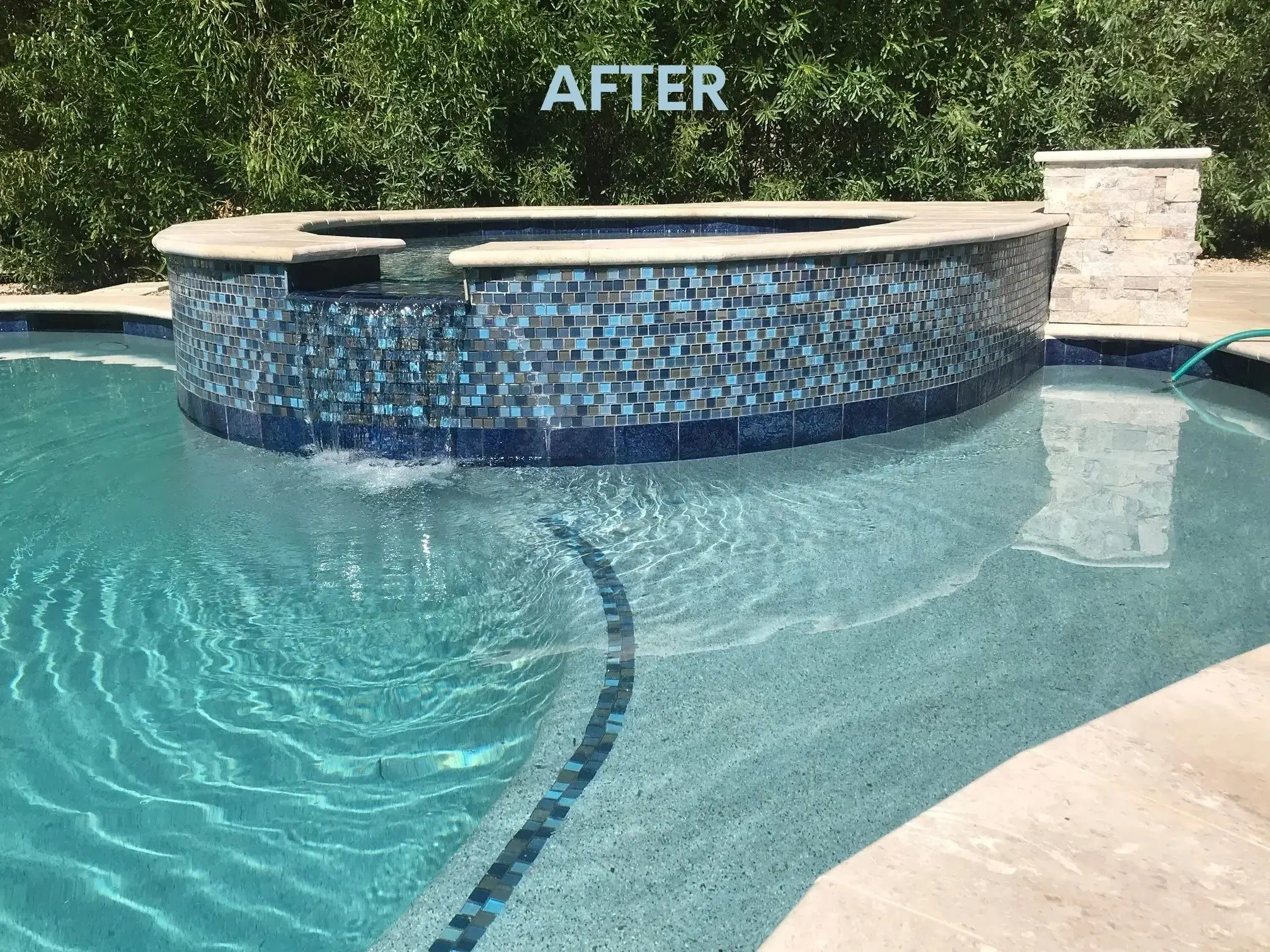 A pool with a blue tile surround and a black tile trim.