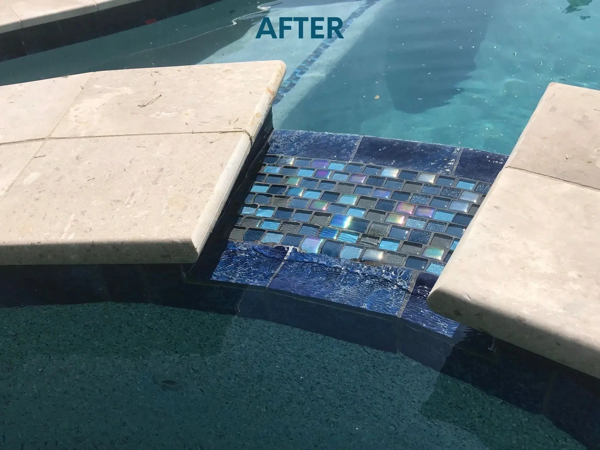 A pool with a tile and stone walkway.