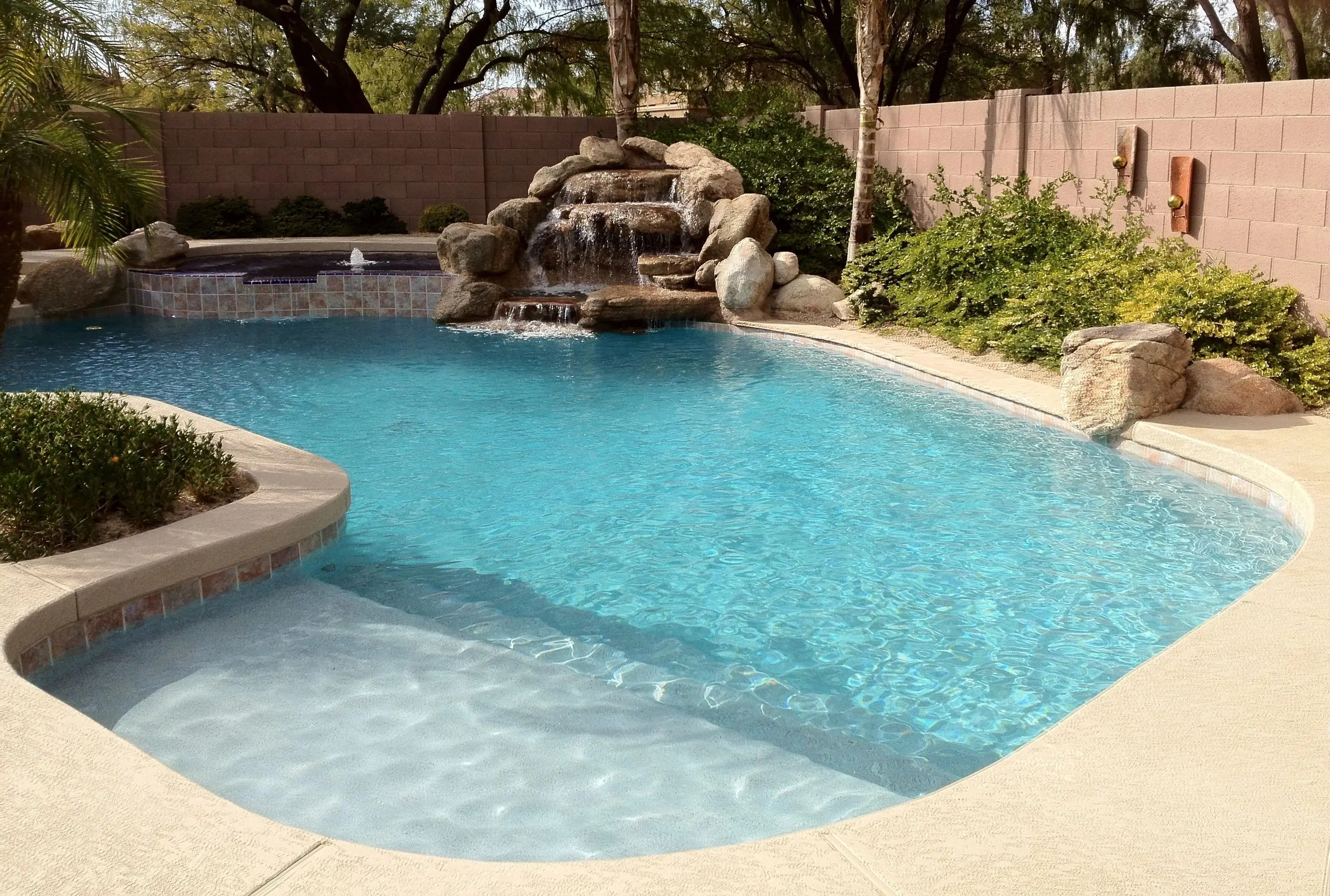 A pool with water falling from the top of it.