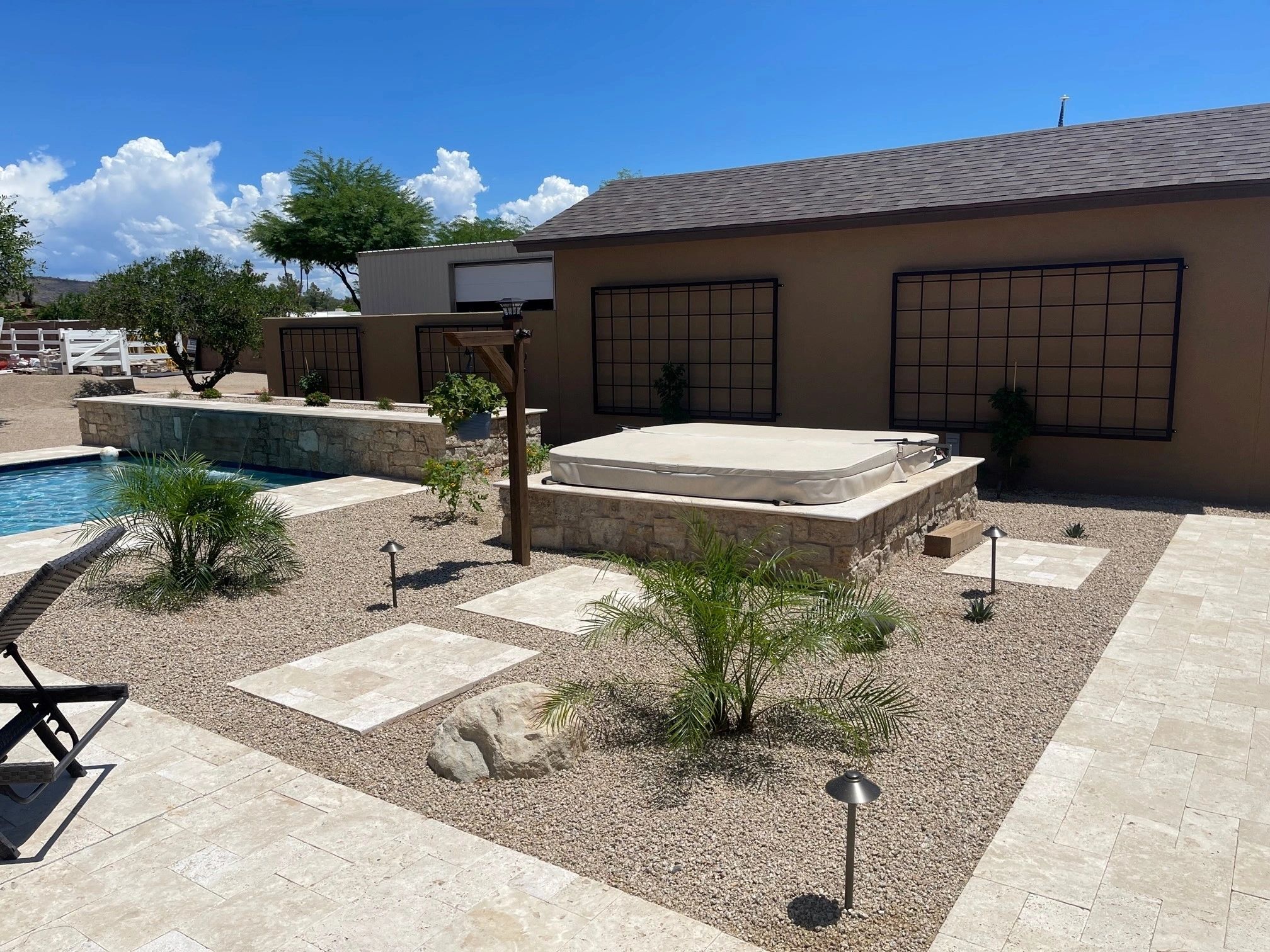 A pool and spa in the middle of a backyard.