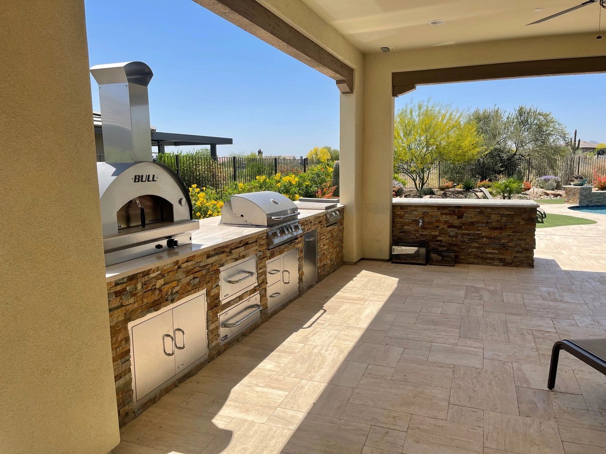 A large outdoor kitchen with an oven and grill.